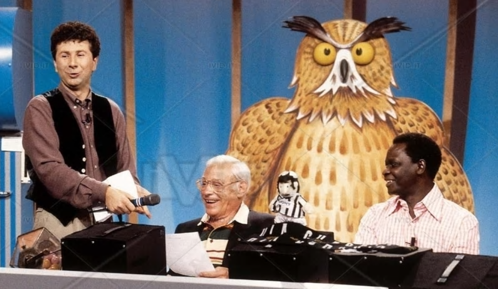 Een screenshot van het tv-programma Quelli che il Calcio met onder andere presentator fabio Fazio, Peter van Wood en op de achtergrond een grote uil